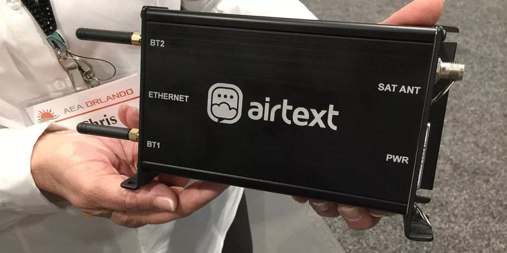 man holding a black avionics electronics box which is the Airtext+ hardware unit